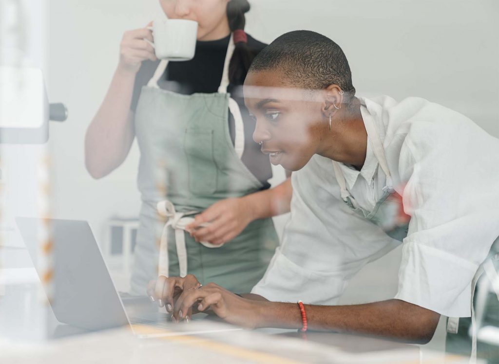 Zwei Frauen arbeiten an Laptop