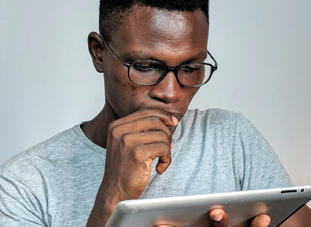 Mann schaut auf Tablet